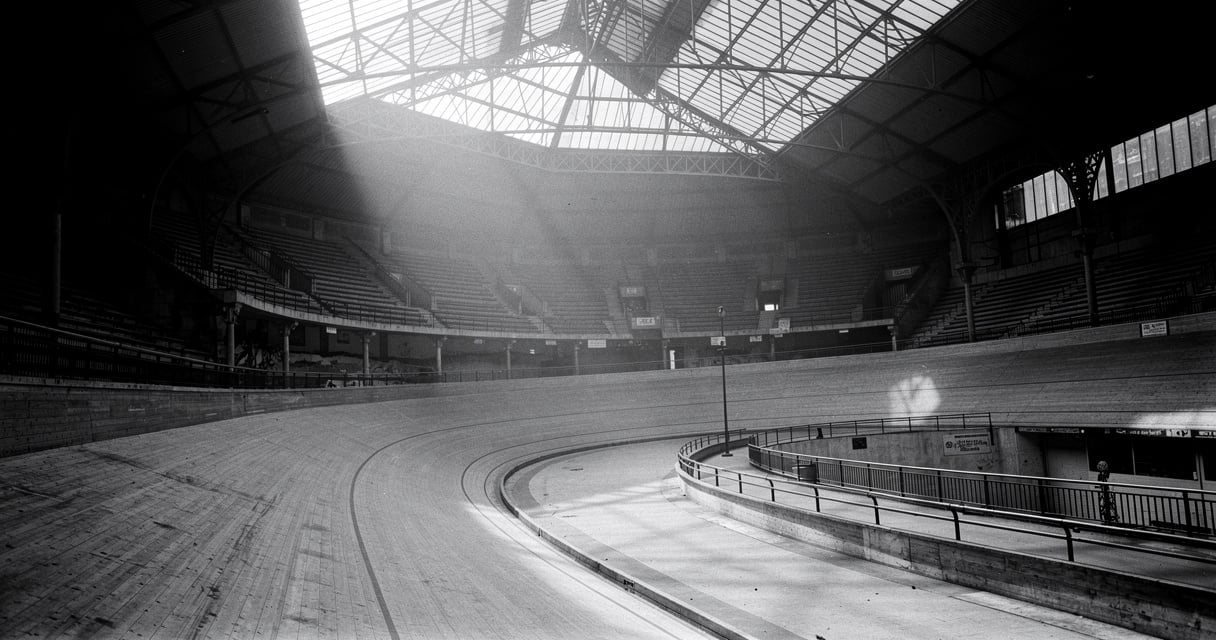 Vue intérieure d'un ancien vélodrome parisien, structure de verre et d'acier, atmosphère historique